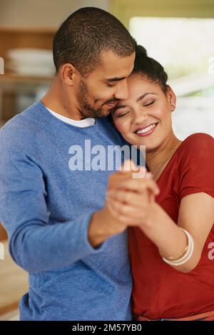 Dancing a beautiful duet of love. a happy young couple dancing together at home. Stock Photo
