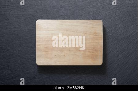 Wooden cutting board against a slate plate from above Stock Photo