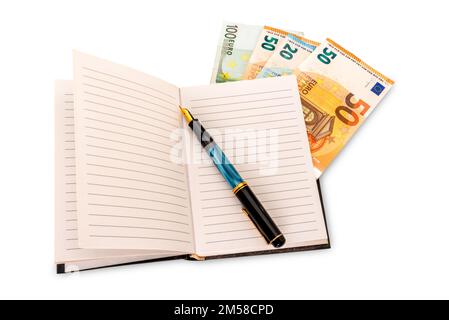 Notebook with vintage fountain pen and euro banknotes between the pages, isolated on white with clipping path, budget, balance sheet concept Stock Photo