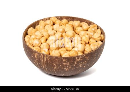 Roasted hazelnuts in bowl isolated on white background. Nuts in a coconut bowl. close up Stock Photo