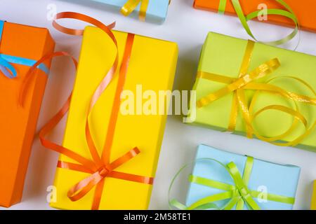 background with holiday gift boxes in different colors with ribbons and bows or gifts on white background, new year, christmas or holidays concept.  Stock Photo