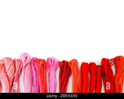 close up group of colorful spools of sewing thread top view on white background Stock Photo