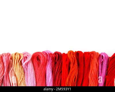 close up group of colorful spools of sewing thread top view on white background Stock Photo