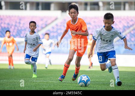 (221227) -- BEIJING, Dec. 27, 2022 (Xinhua) -- File photo taken on July 10, 2022 shows Yang Haoyuan (2nd R) of Hangzhou Pujia Primary School vies with Zhao Yirui (1st R) of Zhejiang Ostrich Football Club during a boy's U11 football match at the first edition of the China Youth Football League (CYFL) in Hangzhou, east China's Zhejiang Province. In June, the Workplan for the China Youth Football League (CYFL) (2022-2024) was released by the Ministry of Education, the State General Administration of Sport and the Chinese Football Association. From July 10 to late November, a total of 1,443 games Stock Photo