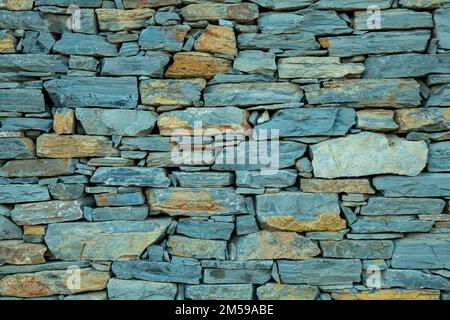wall of mixed gray and assorted-colored rocks texture background. Stock Photo