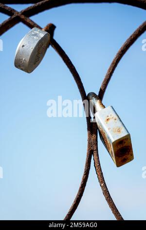 Padlocks attached to an old rusty iron door Stock Photo