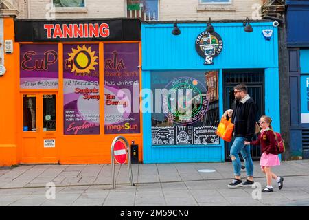 England, Dorset, Bournemouth, Boscombe, Father and Daughter Walking Pass Colourful Shop Fronts *** Local Caption ***  UK,United Kingdom,Great Britain, Stock Photo