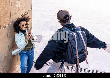 Generation z women having fun outdoor, young students and friends using smart phone to photograph happy and funny moments, social network app concept Stock Photo