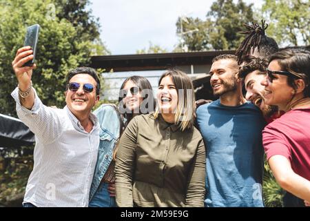 Group of mixed age range friends taking selfie in the garden l on holiday, people having fun on vacation, diverse family and happiness concept Stock Photo