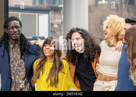 Group of diverse friends having fun, multicultural people smiling and laughing in urban context Stock Photo