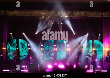 Defocus music band on the stage. Bands silhouettes on a concert. Guitarist on stage for background, soft focus and blur concept. Viva magenta color. O Stock Photo