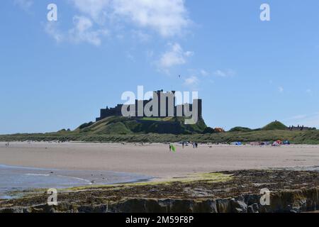 Bamburgh Castle and rocks Stock Photo