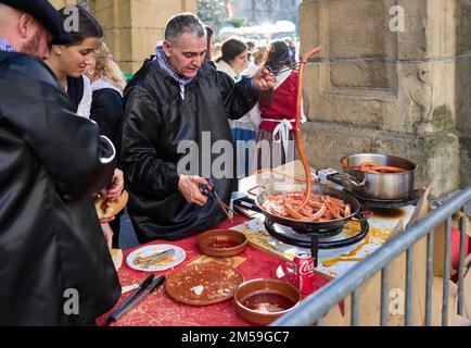 Basque farmers frying Txistorra for the typical street food of the Santo Tomas Fair on Saint Thomas's day, Talos. Stock Photo