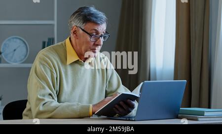 Senior older male online distant teacher webinar speaker tutor coach talking to webcam of laptop video training vlog online conference call old man Stock Photo