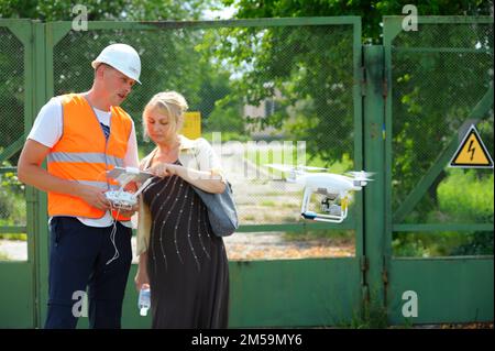 Operator adjusting industrial pro drone before launching it for checking power transmission lines. July 10, 2018. Kyiv, Ukraine Stock Photo