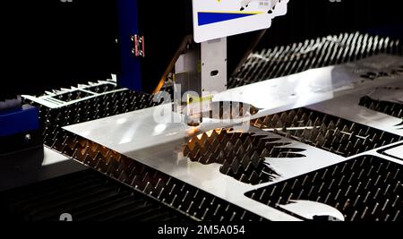 CNC laser cutting machine cutting metal sheet in factory. Industrial manufacture. Stock Photo