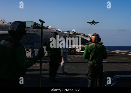 PHILIPPINE SEA (Feb. 13, 2022) U.S. Navy Sailors with the Nimitz-class aircraft carrier USS Abraham Lincoln (CVN 72) observe flight operations in support of Jungle Warfare Exercise 22 (JWX 22) across Okinawa, Japan, Feb. 13, 2022. JWX 22 is a large-scale field training exercise focused on leveraging the integrated capabilities of joint and allied partners to strengthen all-domain awareness, maneuvering, and fires across a distributed maritime environment. Stock Photo
