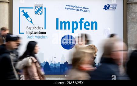 Munich, Germany. 27th Dec, 2022. Passers-by walk past a vaccination center on Marienplatz in the city center with the inscription 'Bayerisches Impfzentrum München - Impffen'. Credit: Sven Hoppe/dpa/Alamy Live News Stock Photo