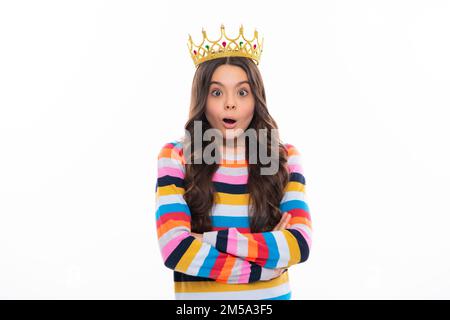 Portrait of ambitious teenage girl with crown, feeling princess, confidence. Child princess crown on isolated studio background. Surprised face Stock Photo
