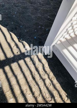 Shadows strips in the sand from a wooden canopy on the beach. Summer background image. Stock Photo