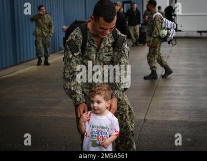 NAVAL AIR STATION WHIDBEY ISLAND, Wash.  -Aviation Electronics Technician 1st Class Justin Rowe, assigned to the “Gauntlets” of Electronic Attack Squadron (VAQ) 136 greets his son after returning to Naval Air Station Whidbey Island, Washington, Feb 14, following an eight-month deployment to U.S. 3rd and 7th Fleet areas of operations as part of the Carl Vinson Carrier Strike Group. Stock Photo