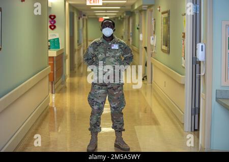 Spc. Muhammad Lebbie, an infantrymen with the 1st Battalion, 175th Infantry Regiment C Company, poses for a photo at Doctors Community Hospital Luminous in Lanham, Maryland, on Feb. 14, 2022. Lebbie is proud of his service and wants to do all he can to help end the COVID-19 pandemic. At the direction of Gov. Larry Hogan, up to 1,000 MDNG members were activated to assist state and local health officials with their COVID-19 response to include the distribution of COVID-19 test kits, 20 million KN95 and N95 masks, and other personal protective equipment and to provide support to skilled nursing f Stock Photo