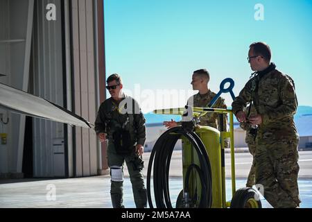 (From left to right) Maj. Mason Locke, 8th Fighter Squadron instructor pilot; Airman 1st Class Holden Wylie, 8th Aircraft Maintenance Unit F-16 Viper assistant dedicated crew chief and Airman 1st Class Kevin Wood, 8th AMU F-16 assistant dedicated crew chief, conduct pre-flight inspections, Feb. 14, 2022, on Holloman Air Force Base, New Mexico. Prior to launch, pilots walk around the aircraft and conduct the final pre-flight checks with the crew chiefs. Stock Photo