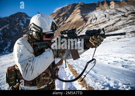 An Italian soldier from the 3rd Alpini Regiment engages targets with a M4A1 for a weapon familiarization during an integrated marksmanship range alongside U.S. Army paratroopers assigned to the 173rd Airborne Brigade. This training is part of Exercise Steel Blizzard at Pian dell’Alpe in Usseaux, Italy on Feb. 15, 2022.     Exercise Steel Blizzard is an Italian Army-hosted multinational mountain and arctic warfare training exercise. Three reconnaissance platoons from the 173rd Airborne Brigade take part in a three-phase training regimen with the 3rd Alpini Regiment to expand force capabilities Stock Photo