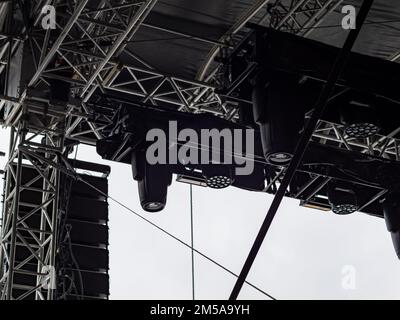 Lighting equipment mounted to a truss frame construction. Outdoor stage concert at the ski opening 2022. Professional entertainment equipment. Stock Photo