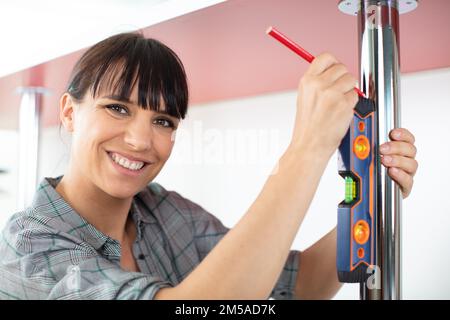 happy woman holding pencil while making marks on the table Stock Photo