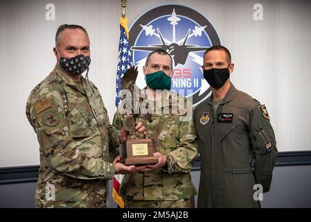 CRYSTAL CITY, VA. (Feb. 16, 2022) - F-35 Joint Program Executive Officer (PEO), Lt. Gen. Eric Fick (far left), presents the prestigious Order of Daedalians Colonel Franklin C. Wolfe Weapons System Award for 2020 to F-35 Dual Capable Aircraft (DCA) Team Materiel Leader Lt. Col. Jason W. Shirley (center) and Commander, 461st Flight Test Squadron/Director, F-35 Integrated Test Force Lt. Col. Christopher “SIN” Campbell (far right). In 2020, the then 26-person F-35 DCA Team completed a vital development test campaign a full year ahead of schedule, which earned them this award. The award is presente Stock Photo