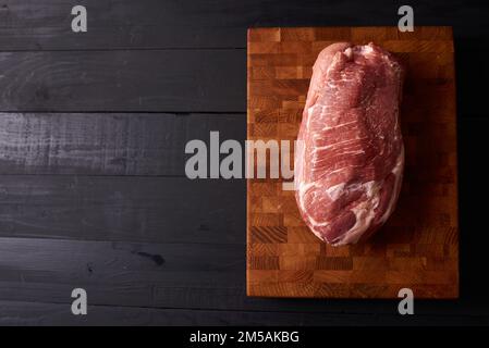 Fresh raw beef steak on wooden cutting board, top view. Served over black background. Web design banner with copy space. Organic healthy fresh food Stock Photo