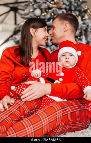 Happy family near the Christmas tree for the New Year Stock Photo