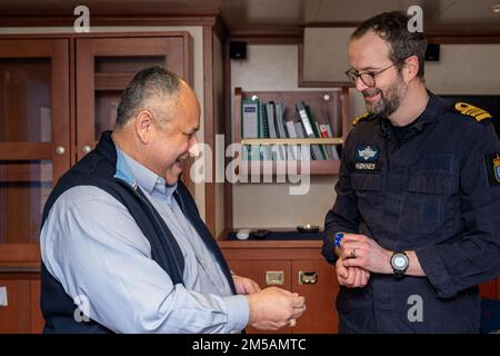 BERGEN, Norway (Feb. 16, 2022) — Secretary of the Navy Carlos Del Toro exchanges challenge coins with Norwegian Cmdr. Lars Ole Høknes, commanding officer of HNoMS Thor Heyerdahl (F314), aboard the ship in Bergen, Norway, Feb. 16, 2022. Secretary Del Toro is in Norway to visit U.S. service members and Norwegian government leaders to reinforce existing bilateral and multilateral security relationships between the U.S. Navy and the Royal Norwegian Navy. Stock Photo