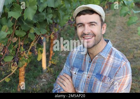 Farmer with arms crossed in vineyard Stock Photo