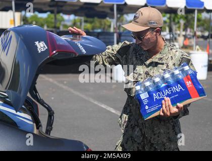 HONOLULU, Hawaii (Feb. 17, 2022) – Electronics Technician (Nuclear) 1st Class Andrew Loera, assigned to Naval Sea Systems Command, hands out water at the Navy Exchange Moanalua Terrace water distribution station. U.S. Navy is working closely with the Hawaii Department of Health, U.S. Environmental Protection Agency and the U.S. Army to restore safe drinking water to Joint Base Pearl Harbor-Hickam housing communities through sampling and flushing, and the recovery of the Red Hill Well. For detailed information, go to: www.navy.mil/jointbasewater. Stock Photo