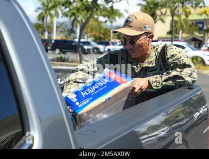 HONOLULU, Hawaii (Feb. 17, 2022) – Electronics Technician (Nuclear) 1st Class Andrew Loera, assigned to Naval Sea Systems Command, hands out water at the Navy Exchange Moanalua Terrace water distribution station. U.S. Navy is working closely with the Hawaii Department of Health, U.S. Environmental Protection Agency and the U.S. Army to restore safe drinking water to Joint Base Pearl Harbor-Hickam housing communities through sampling and flushing, and the recovery of the Red Hill Well. For detailed information, go to: www.navy.mil/jointbasewater. Stock Photo