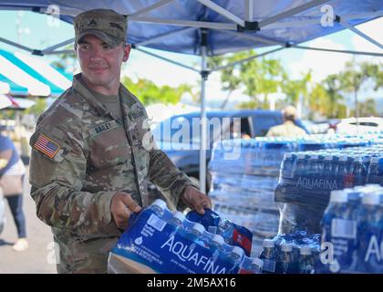 HONOLULU, Hawaii (Feb. 17, 2022) – U.S. Army Sgt. Owen Bailey, assigned to the 95th Engineer Company, 84th Engineer Battalion, 130th Engineer Brigade, hands out water at the Navy Exchange Moanalua Terrace water distribution station. U.S. Navy is working closely with the Hawaii Department of Health, U.S. Environmental Protection Agency and the U.S. Army to restore safe drinking water to Joint Base Pearl Harbor-Hickam housing communities through sampling and flushing, and the recovery of the Red Hill Well. For detailed information, go to: www.navy.mil/jointbasewater. Stock Photo