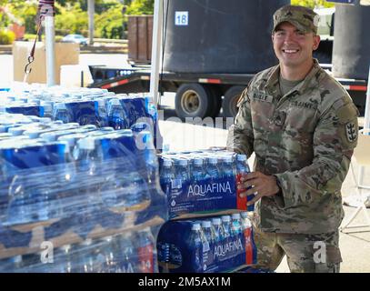 HONOLULU, Hawaii (Feb. 17, 2022) – U.S. Army Sgt. Owen Bailey, assigned to the 95th Engineer Company, 84th Engineer Battalion, 130th Engineer Brigade, prepares to hand out water at the Navy Exchange Moanalua Terrace water distribution station. U.S. Navy is working closely with the Hawaii Department of Health, U.S. Environmental Protection Agency and the U.S. Army to restore safe drinking water to Joint Base Pearl Harbor-Hickam housing communities through sampling and flushing, and the recovery of the Red Hill Well. For detailed information, go to: www.navy.mil/jointbasewater. Stock Photo