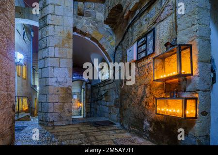 Jerusalem, Israel - December 24, 2022: Alley in the Jewish quarter of the Old City, with various Traditional Menorahs (Hanukkah Lamps) with olive oil Stock Photo