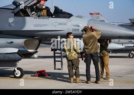 Three U.S. Air Force maintainers from the 52nd Fighter Wing at Spangdahlem Air Base, Germany, prepare an F-16 Fighting Falcon Aircraft after landing at the 86th Air Base, Romania, Feb. 17, 2022. Air Defense operations ensure the protection of allied airspace in the transition from peacetime operations to crisis and conflict. Stock Photo