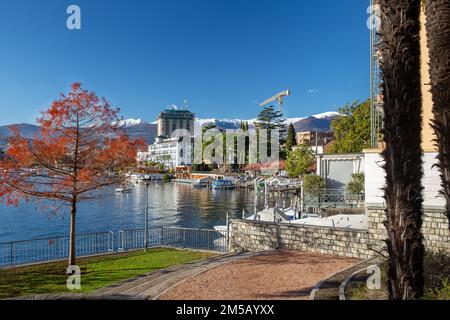 Idyllic winter view of the city of Lugano, behind the snow-capped mountains (Swiss Alps). Near the buildings on the shores of Lake Lugano - excellent Stock Photo