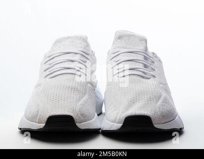 Front view of white sport shoes isolated on studio background Stock Photo