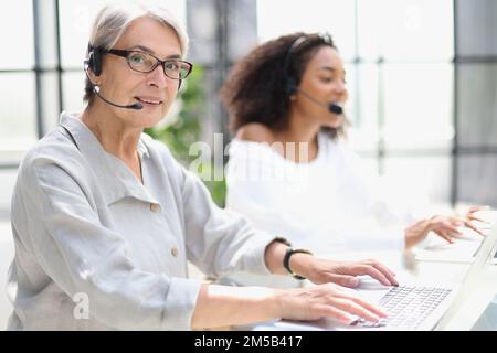 operator woman agent with headsets working in a call centre. Stock Photo