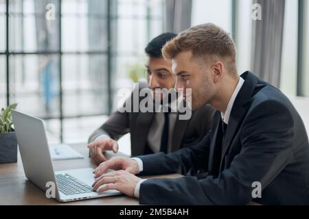 two professional businessmen discussing and using desktop computer in office Stock Photo
