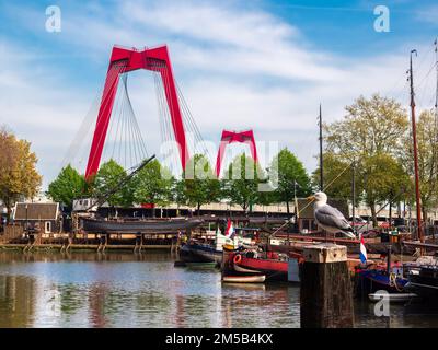 Rotterdam, Netherlands - April 28, 2022: A view at the Willemsbrug, a cable-stayed red bridge with a total span of about 318 meters. Stock Photo