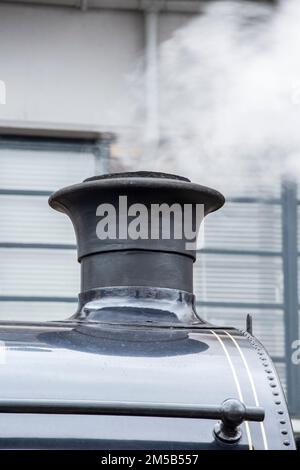 A black steam train funnel with steam Stock Photo