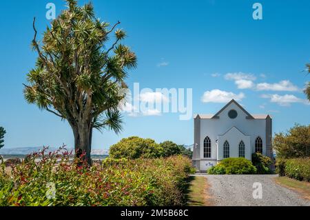 The All Saints Church at Wairongomai on Western Lake Road surrounded by vegetation in New Zealand Stock Photo