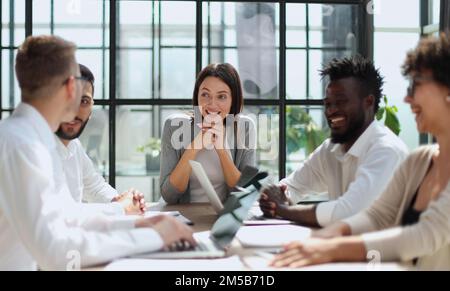 Employees working at computer together, discussing content Stock Photo