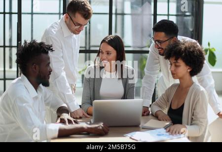 Employees working at computer together, discussing content Stock Photo